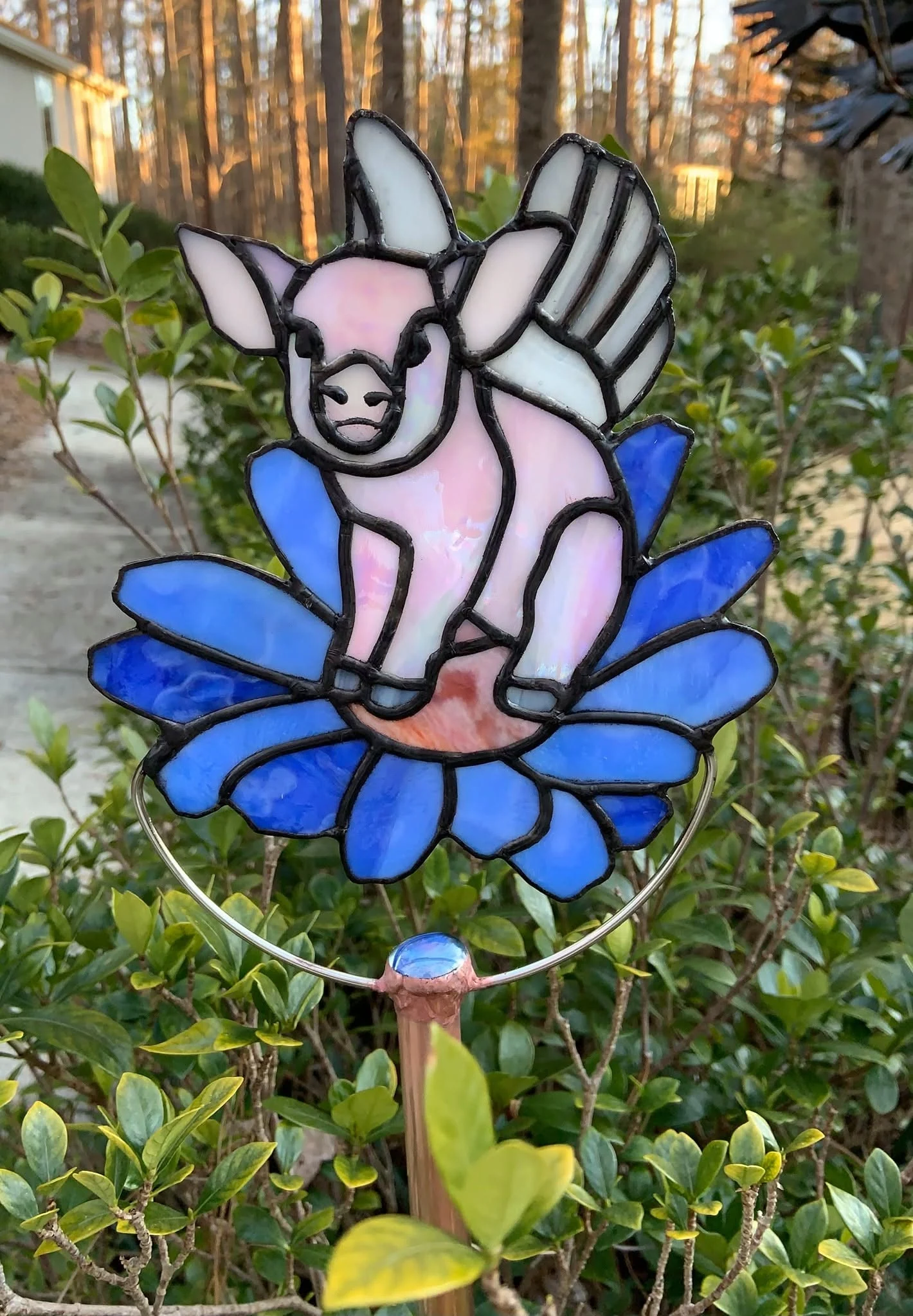 Winged pig and flower garden stake — original photograph