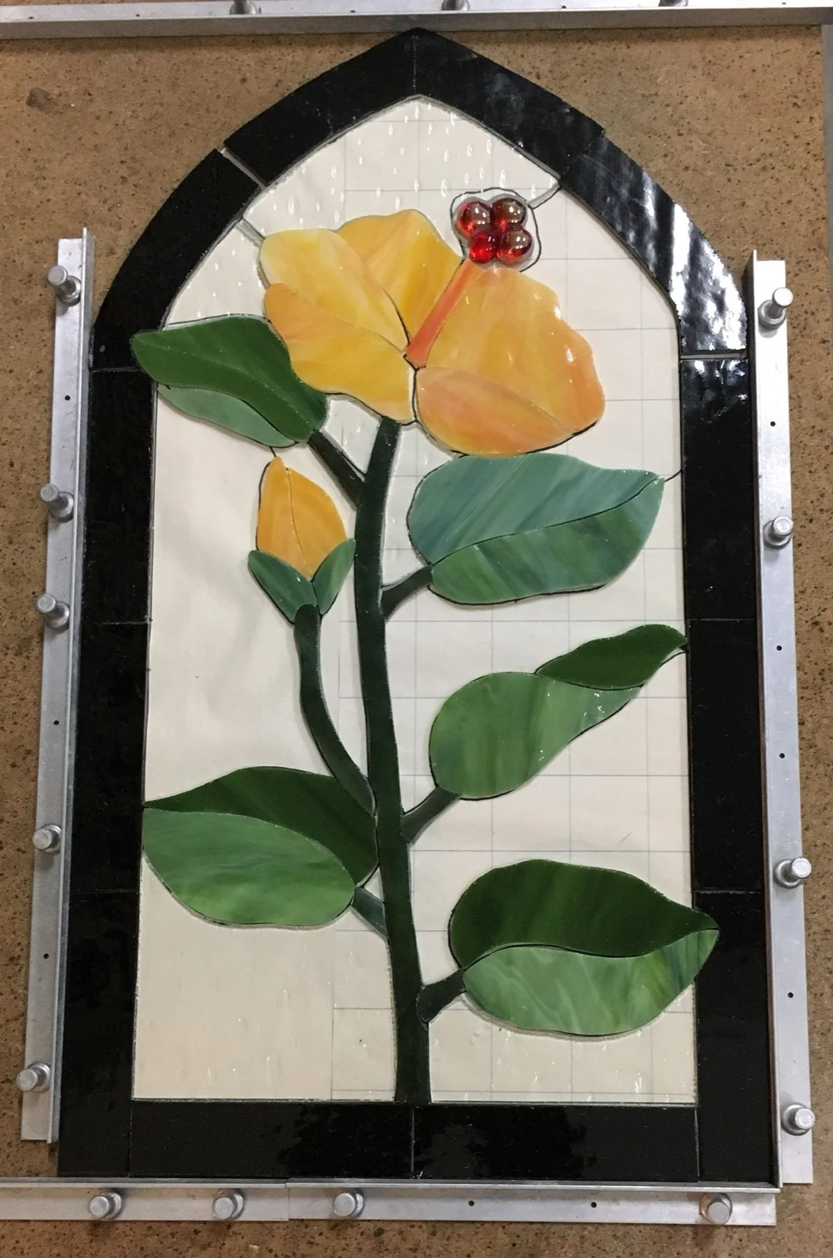 Yellow rose glass arranged on an arched workbench pattern